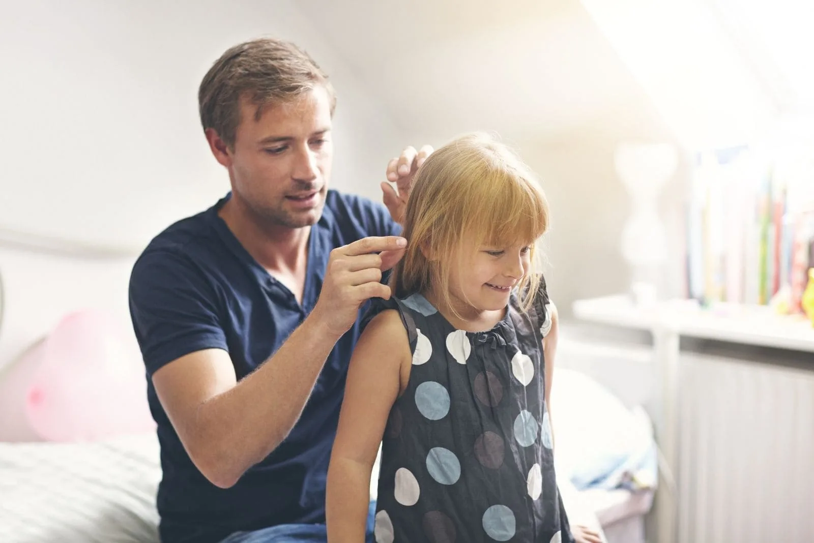 single dad keeping his daughter's hair while sitting inside the room