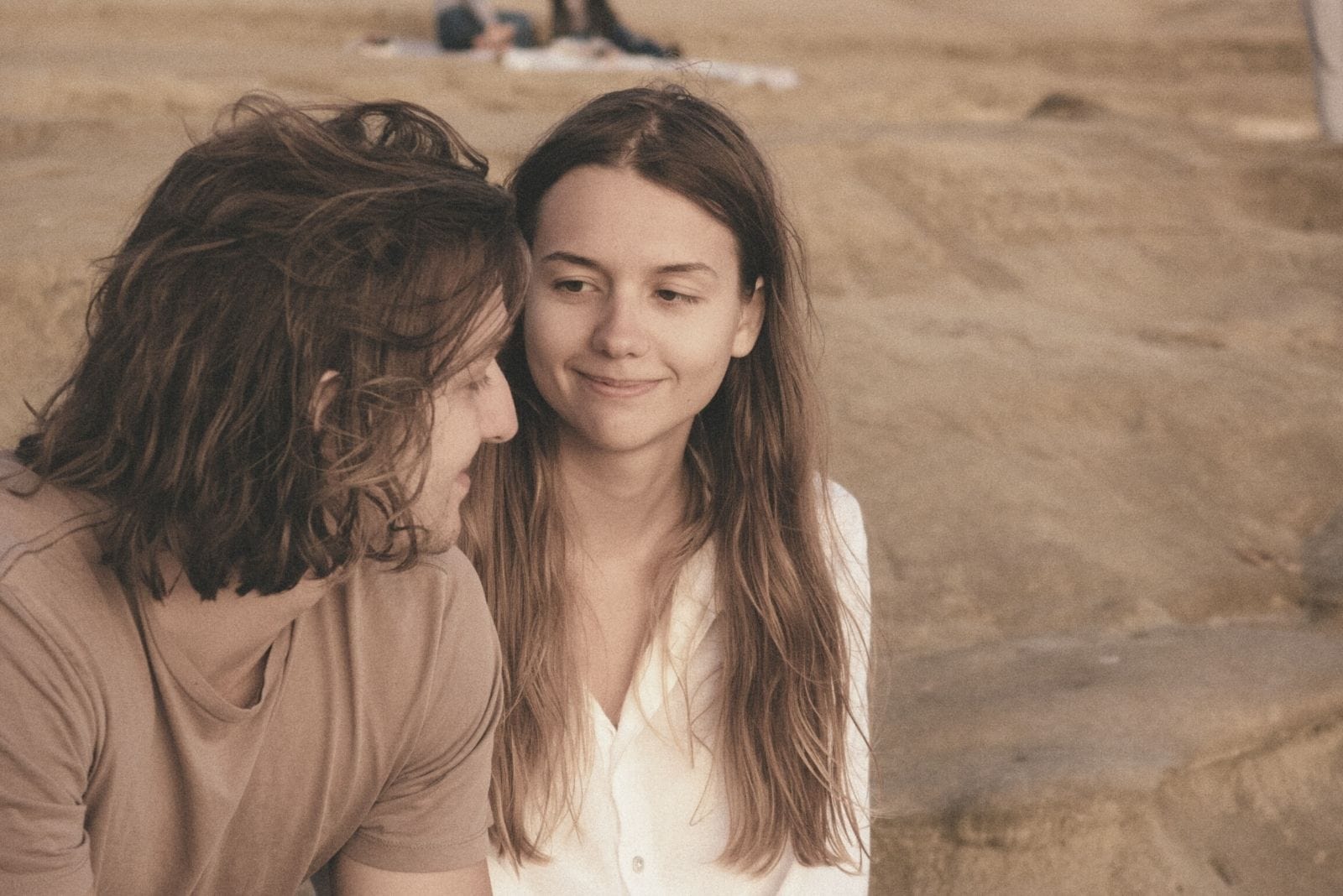 mujer y hombre sonrientes sentados al aire libre