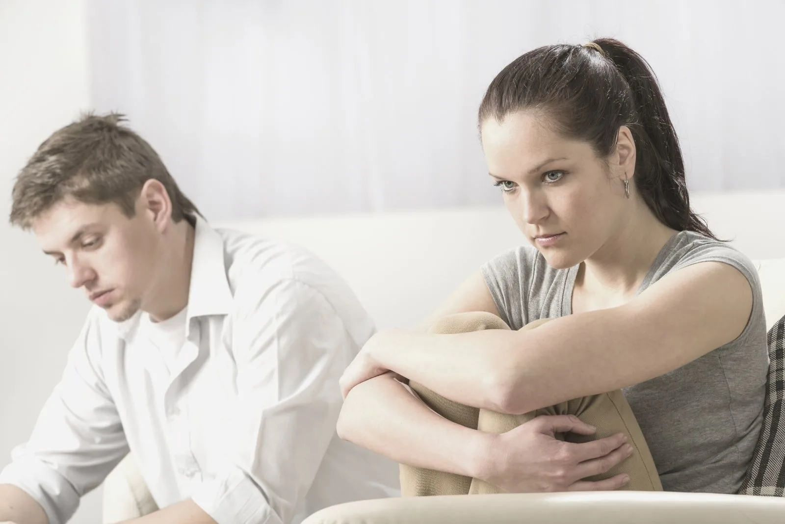 unhappy couple sitting silently in the sofa after an argument
