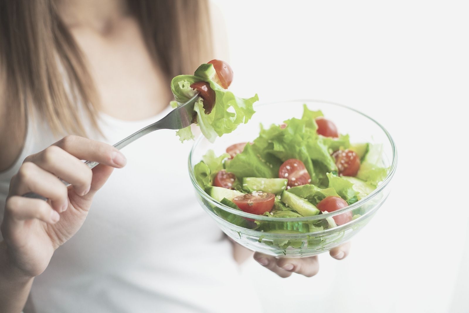 Donna che mangia un'insalata sana in un'immagine ritagliata