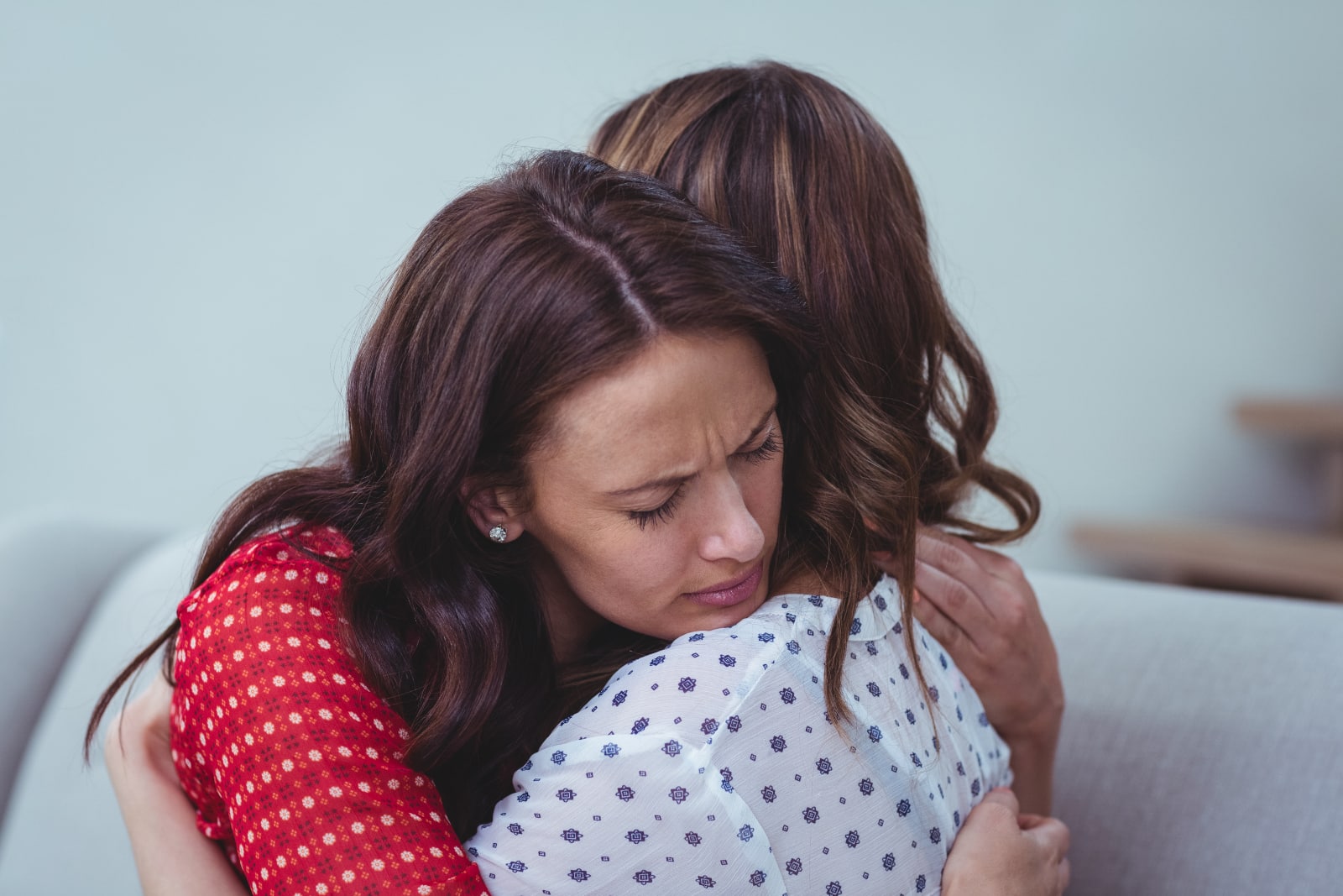 woman embracing her friend at home