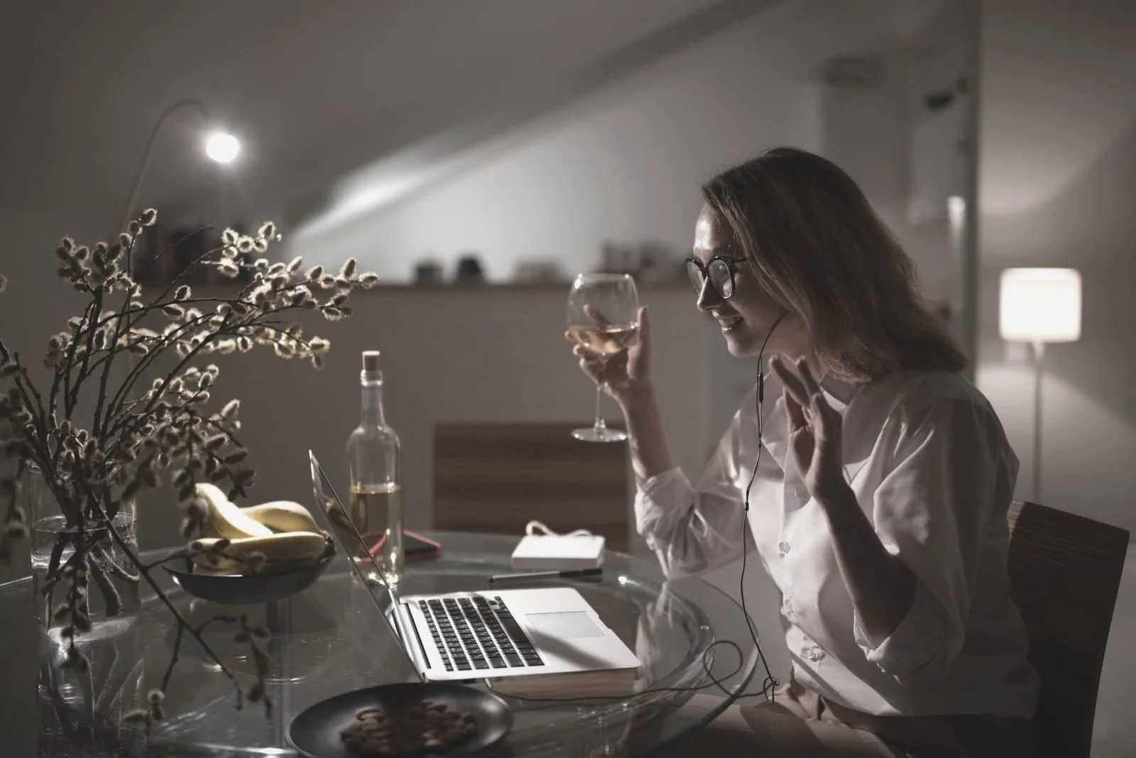 woman having a drink wine while chatting on the laptop during the night