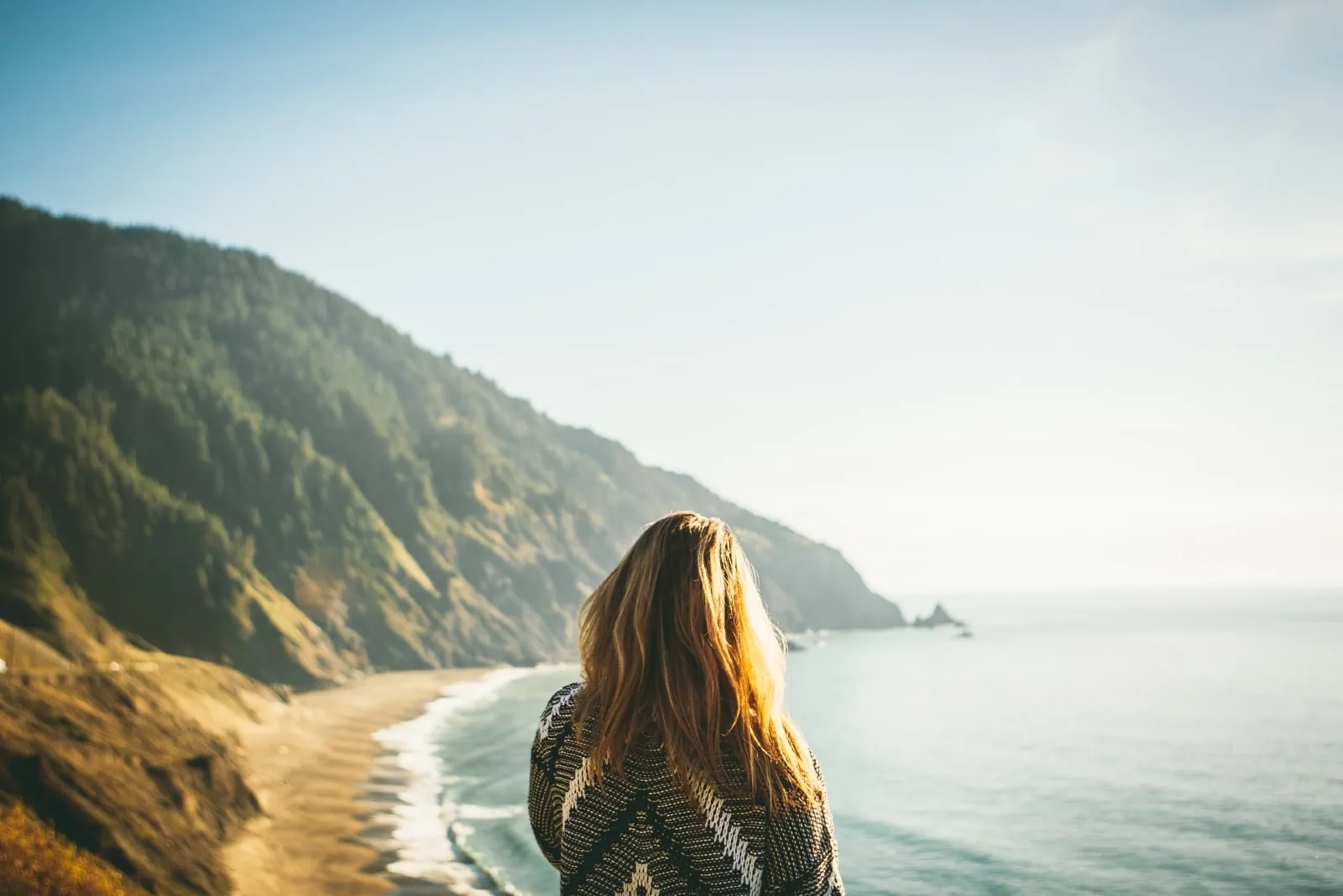 woman in gray sweater looking at ocean