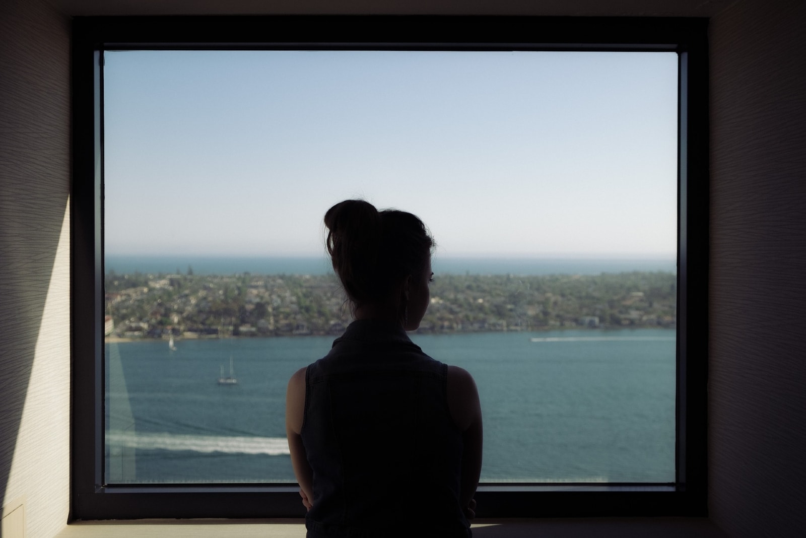 woman in black top standing near window