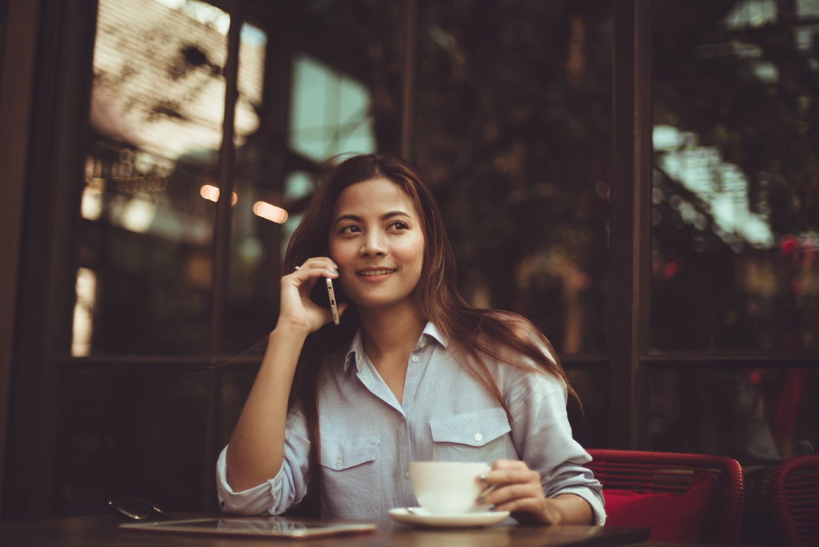 woman talking on the phone while sitting at table