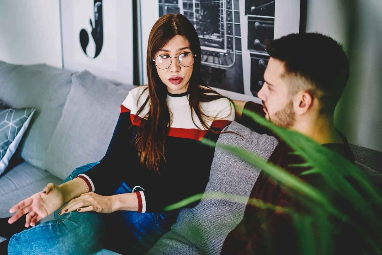 woman talking to man while sitting on sofa