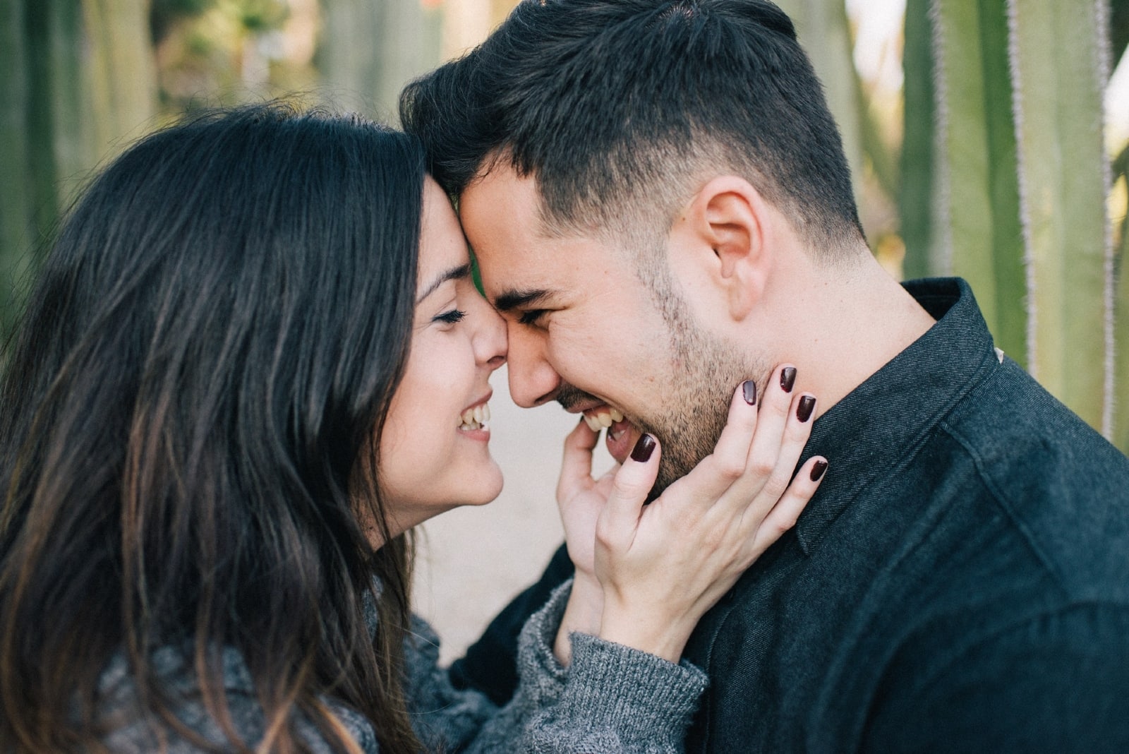 woman touching man's face while standing near cactuses