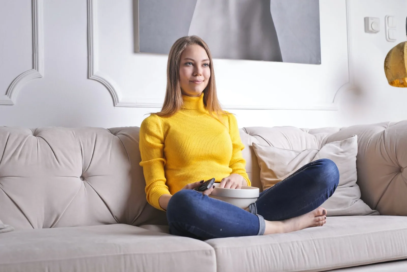 woman watching tv while sitting on sofa