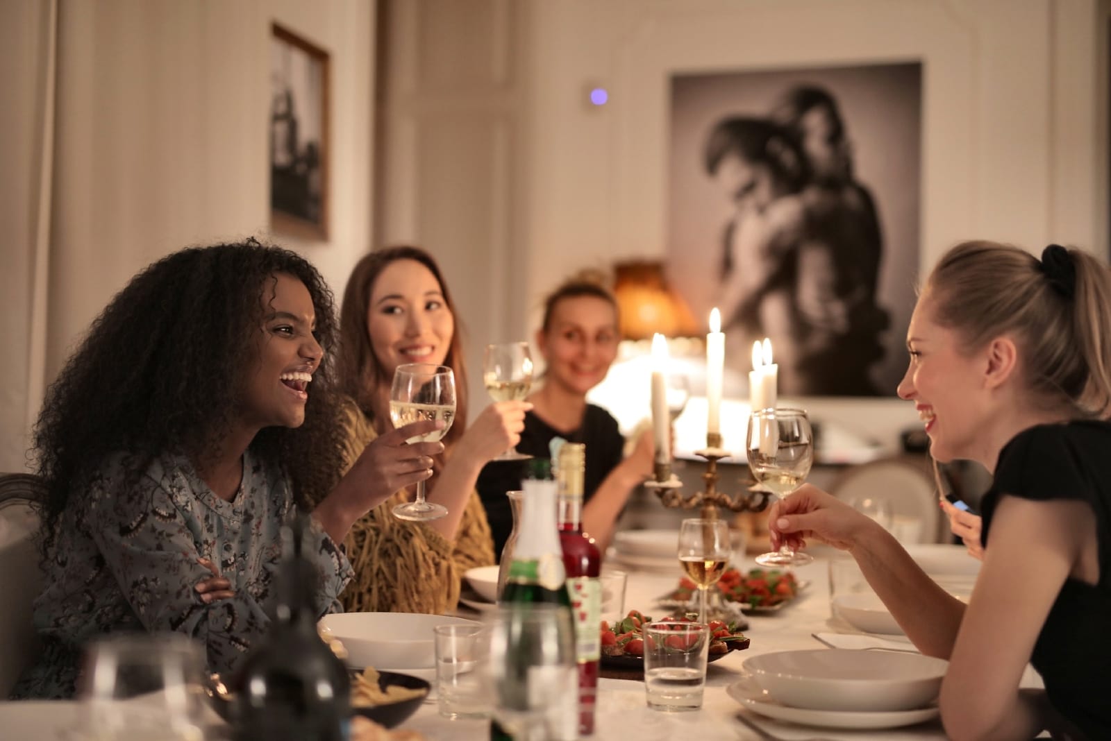 mujeres sosteniendo copas de vino sentadas a la mesa