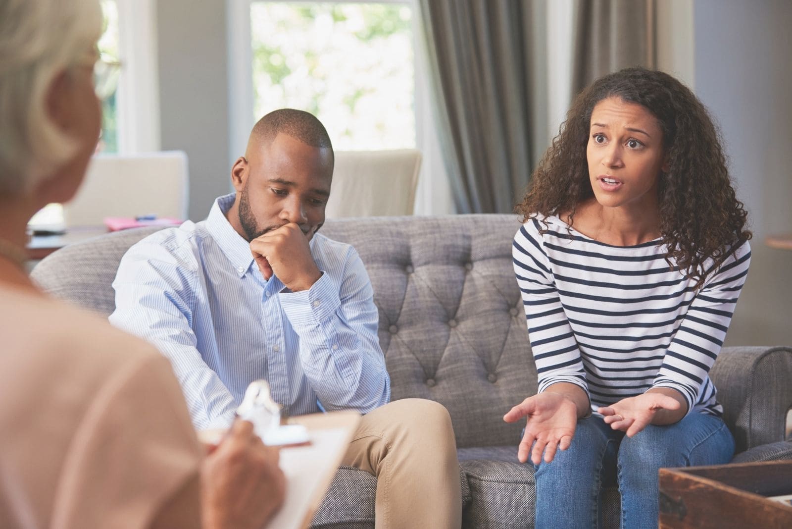 Giovane coppia afroamericana a colloquio con un consulente matrimoniale in salotto