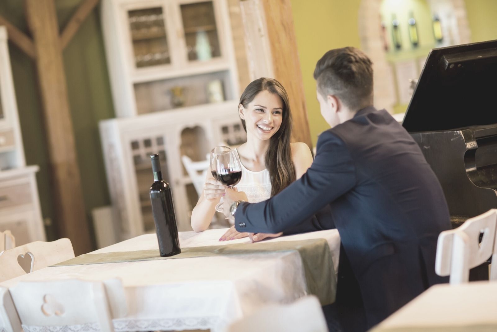 young couple drinking red wine during a date in a restaurant