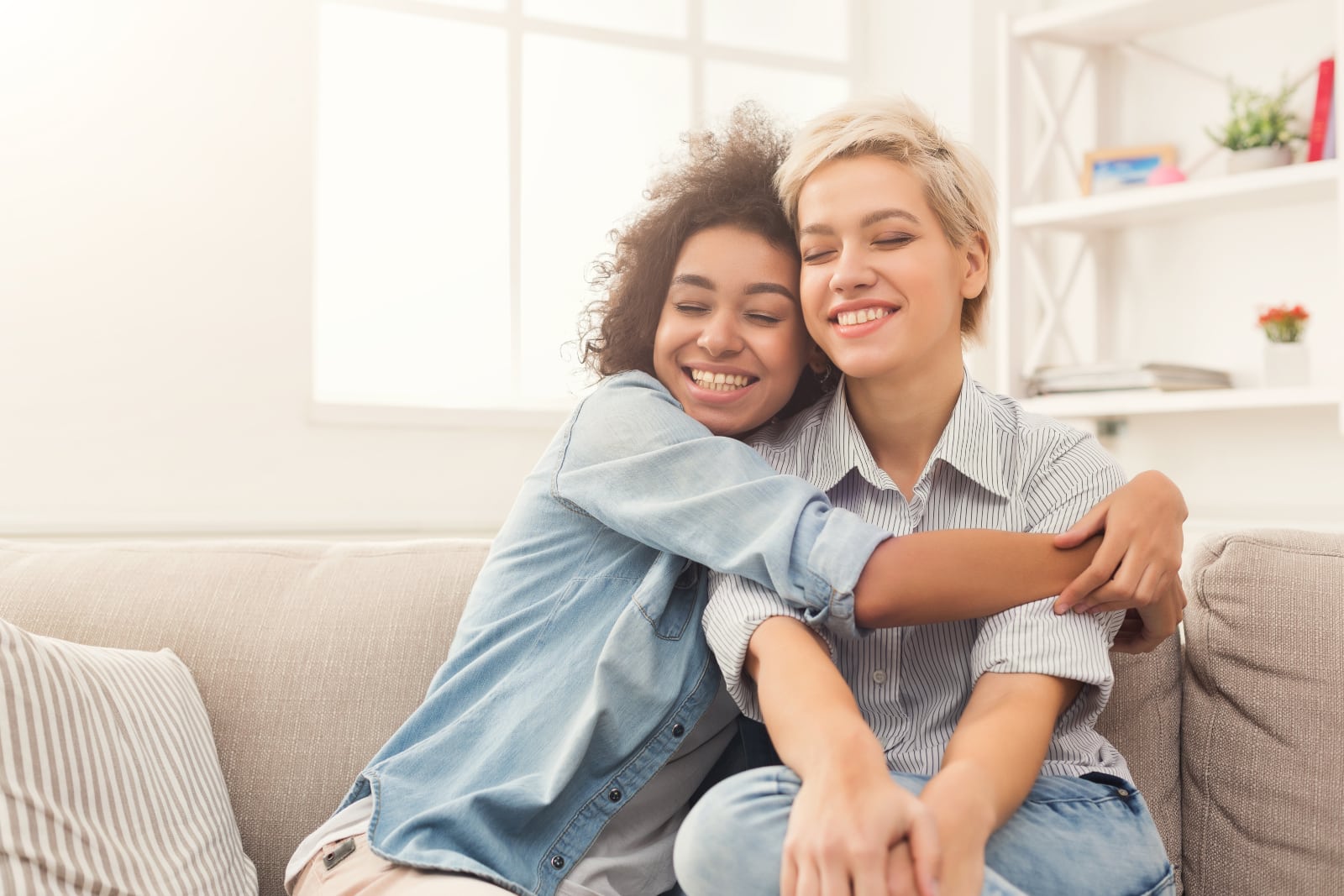 young woman hugging her friend at home