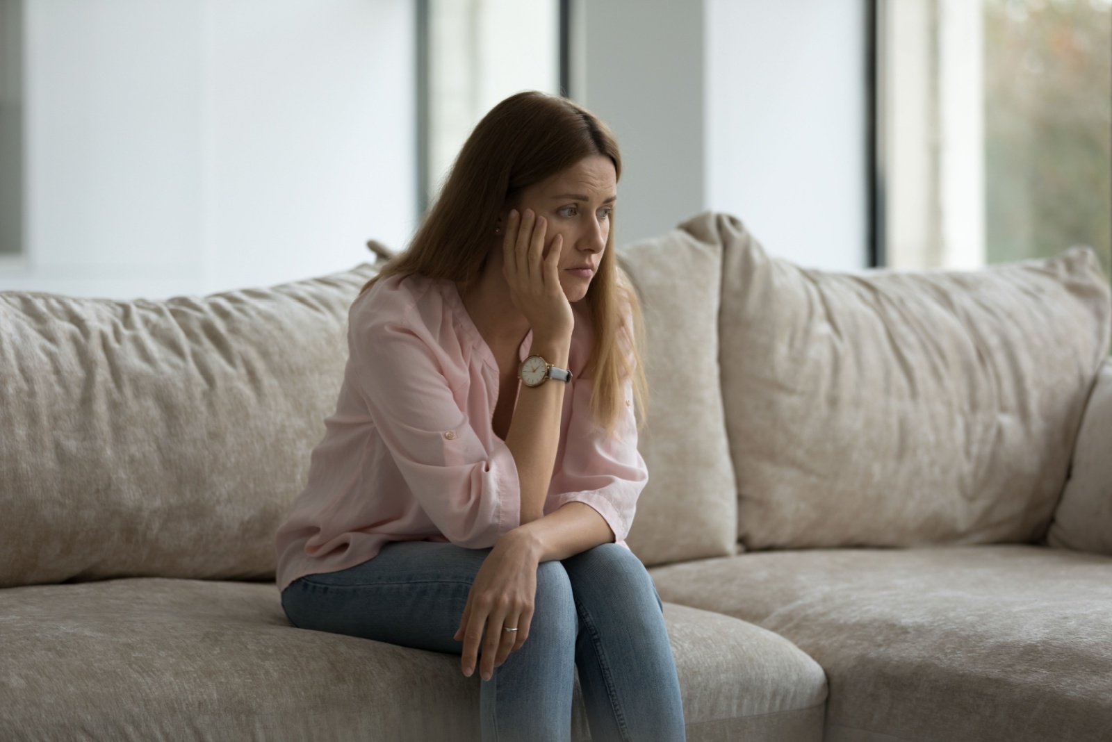 mujer triste sentada en el sofá