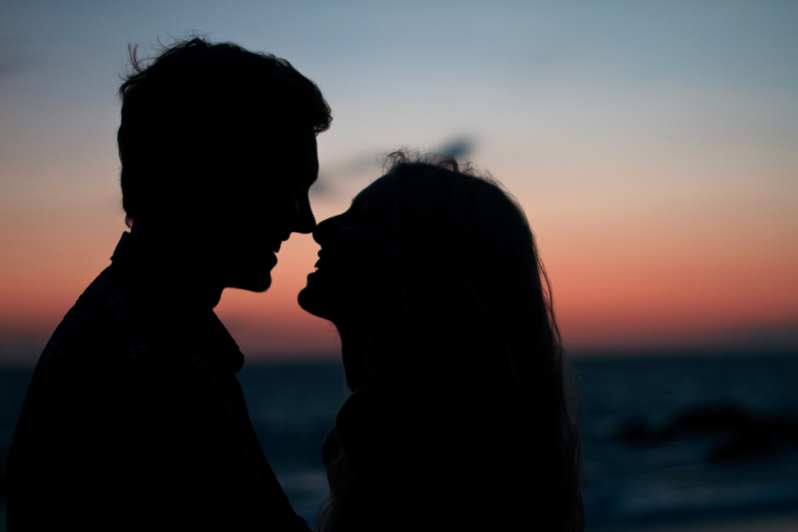 man and woman making eye contact during sunset