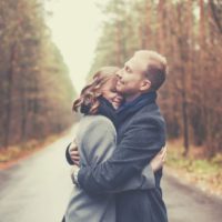 doce casal abraçado no meio da estrada durante o outono