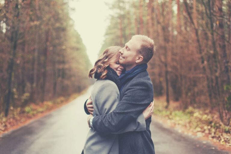 sweet couple embracing in the middle of the road during autumn season