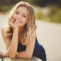 a woman with long blonde hair laughs