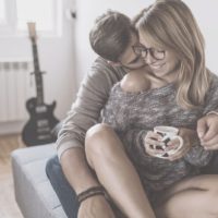 flirty couple hugging inside the livingroom while drinking coffee