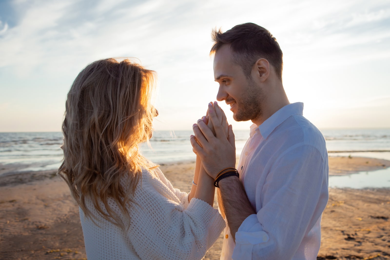 A young couple sensually holding hands