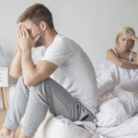 couple having a family problem sitting in bed trying to resolve inside the bedroom