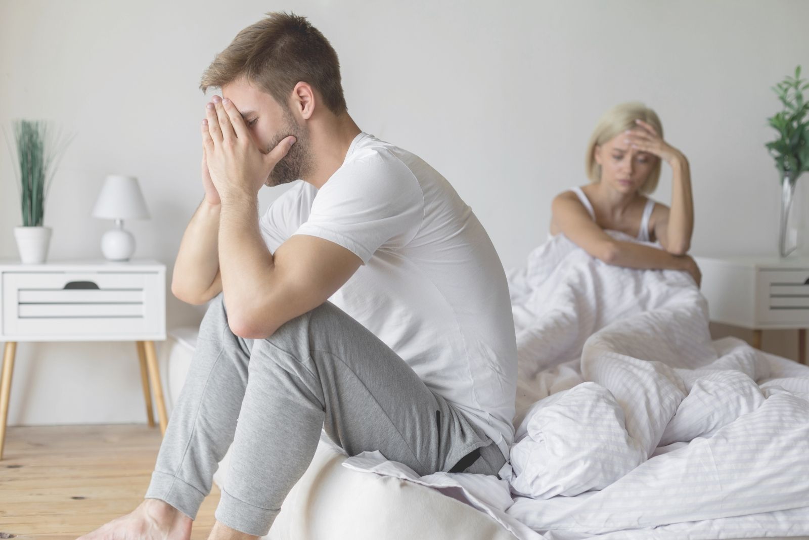 couple having a family problem sitting in bed trying to resolve inside the bedroom