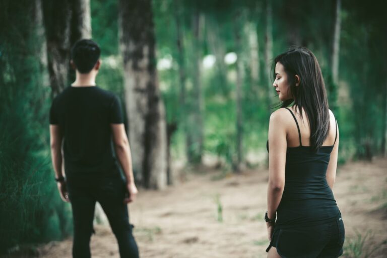 a sad woman looks after a man walking away from her