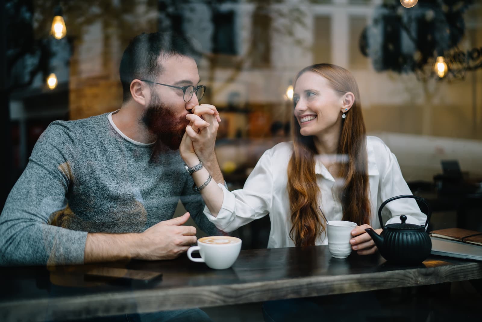 Loving young man kissing hand of woman