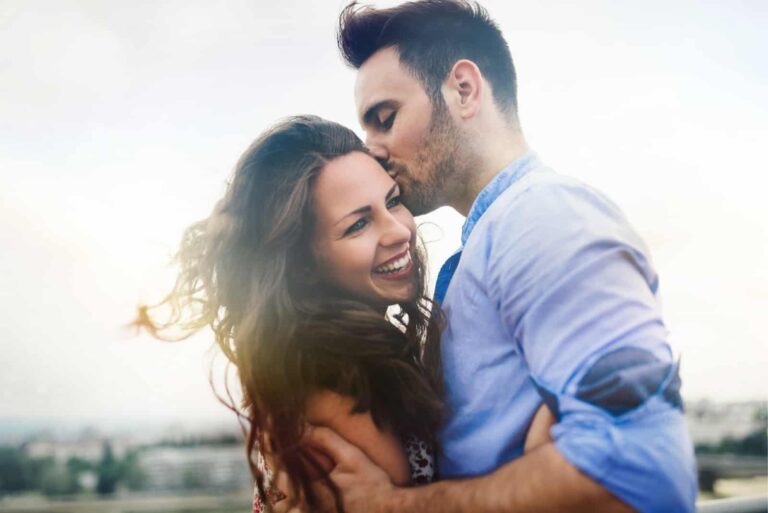 man in blue shirt kissing woman outdoor