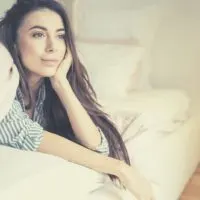 dreamy woman lying in bed looking in front of her
