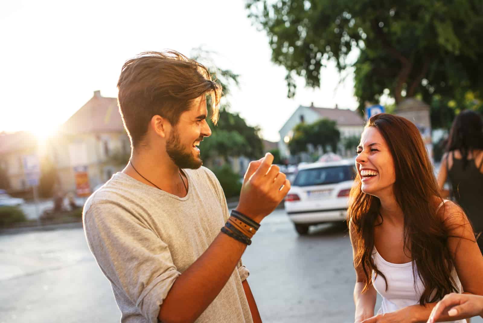 um homem e uma mulher estão na rua a rir-se