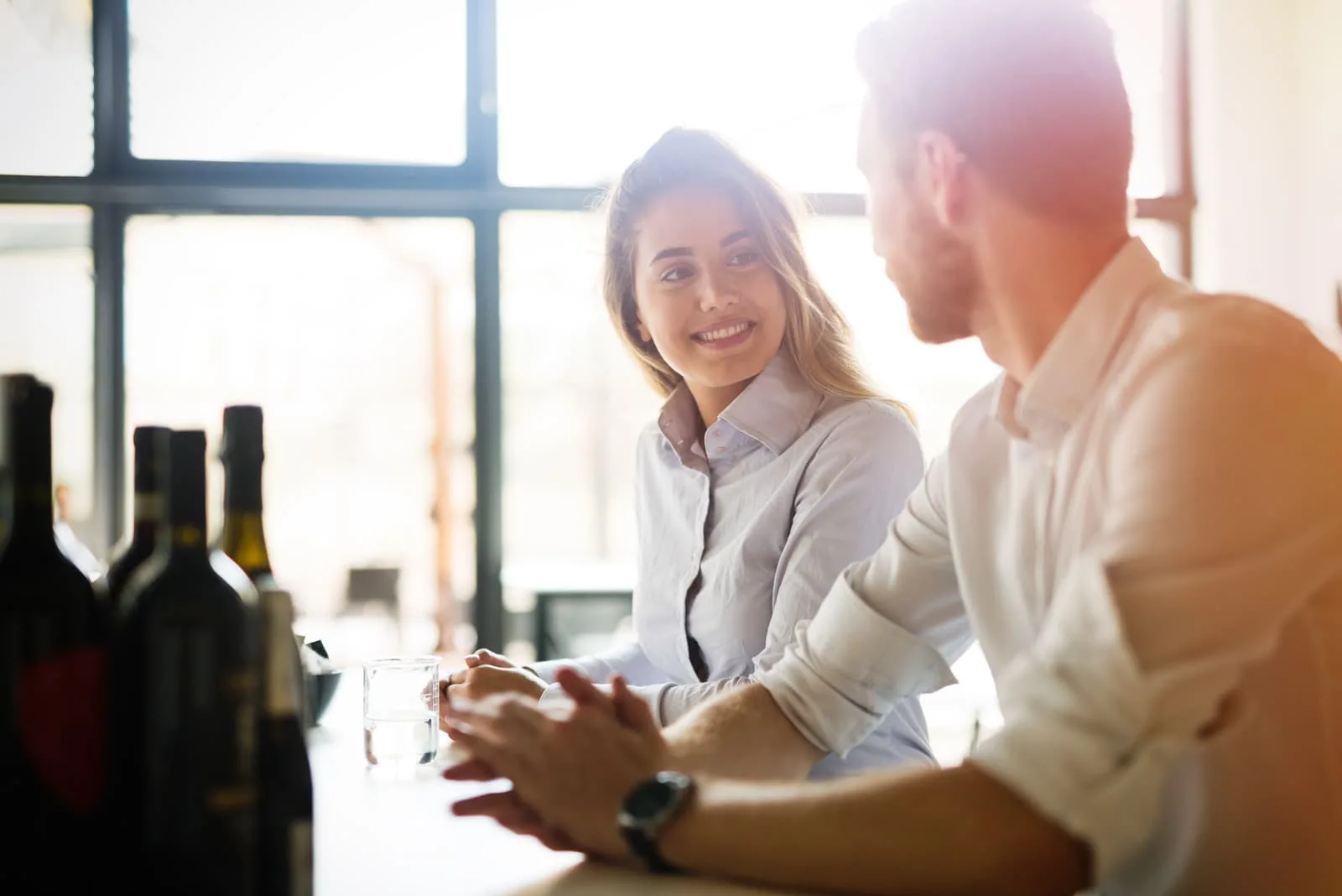 a man and a woman sit at a table and talk