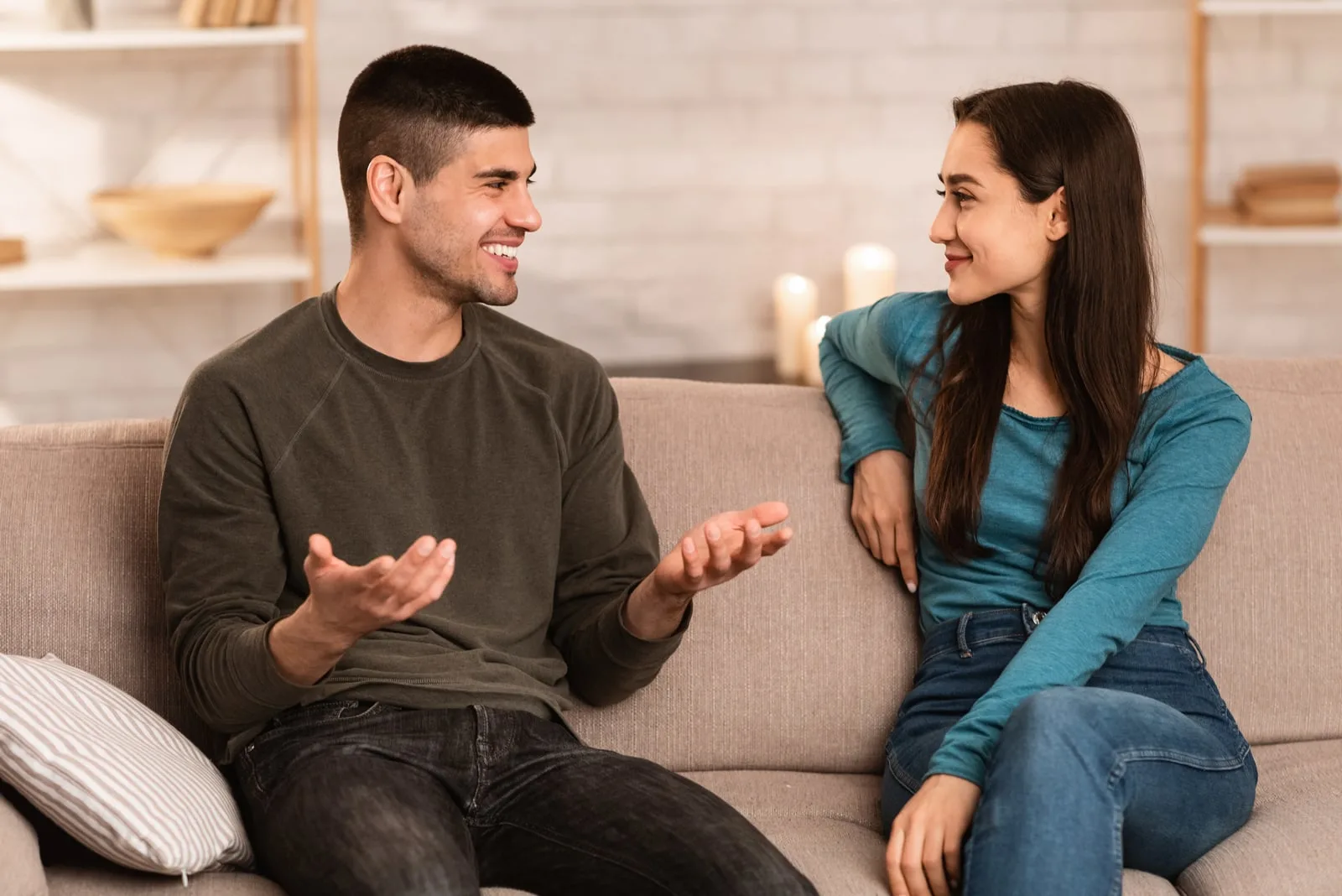 a man and a woman sit on the couch and talk