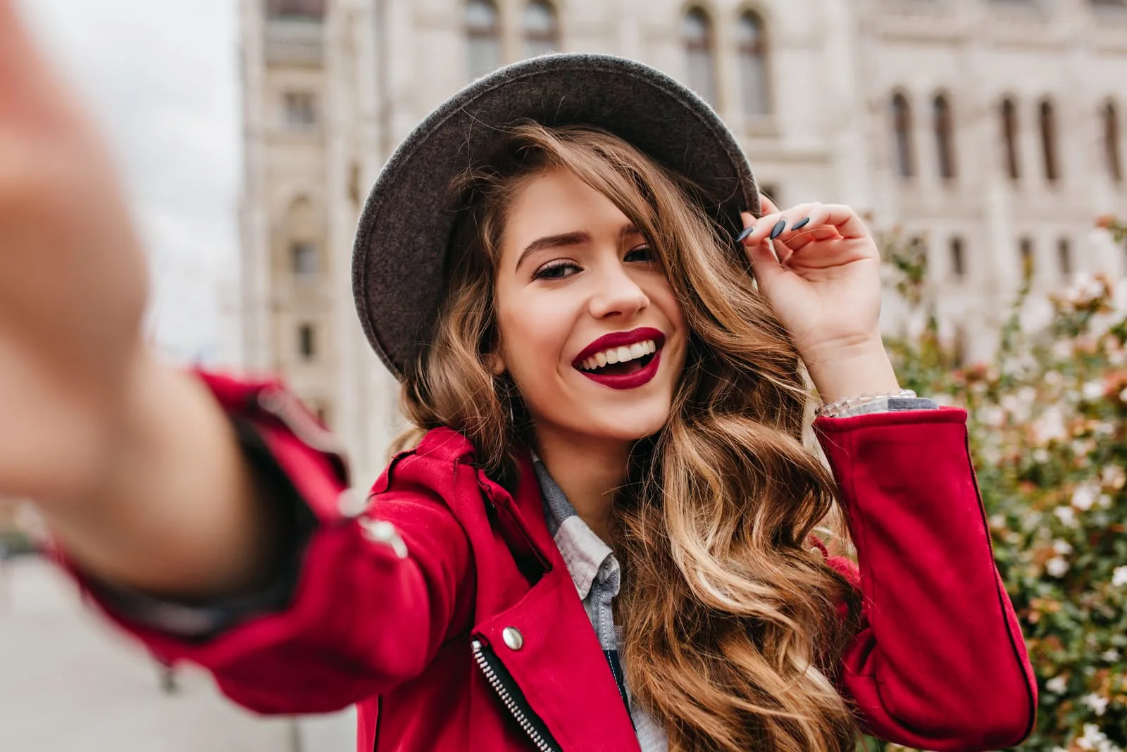 a woman with long brown hair with a hat is pictured