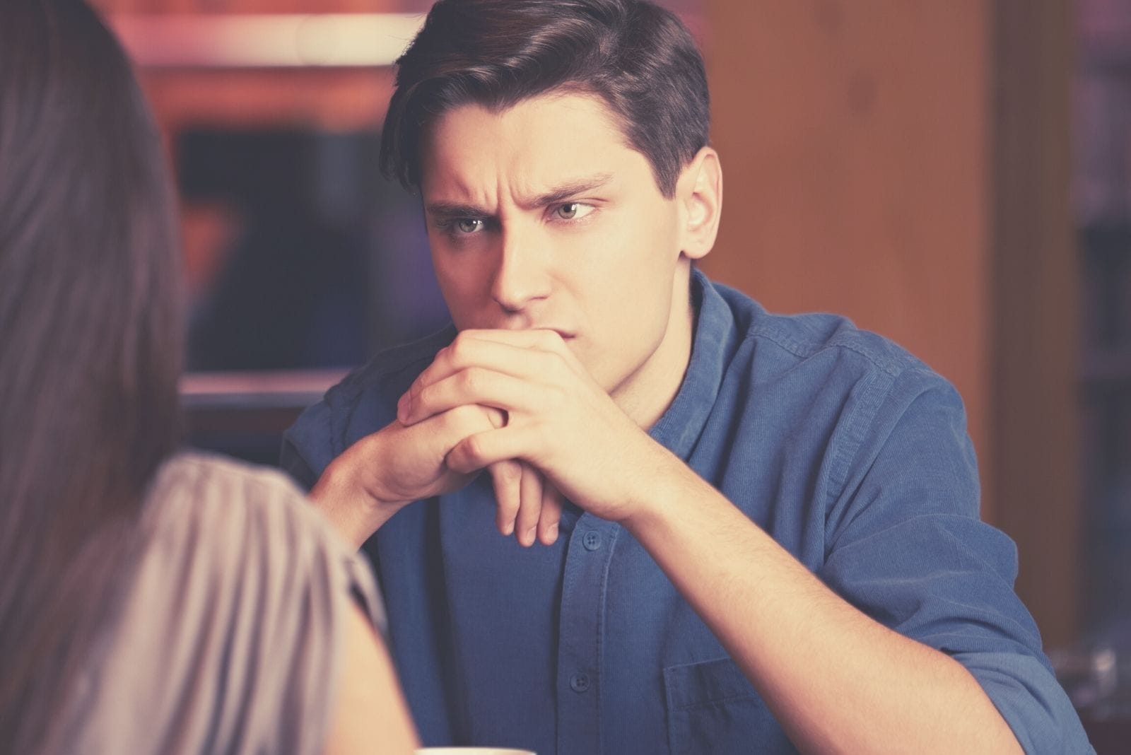  hombre atento escuchando a su novia dentro del restaurante