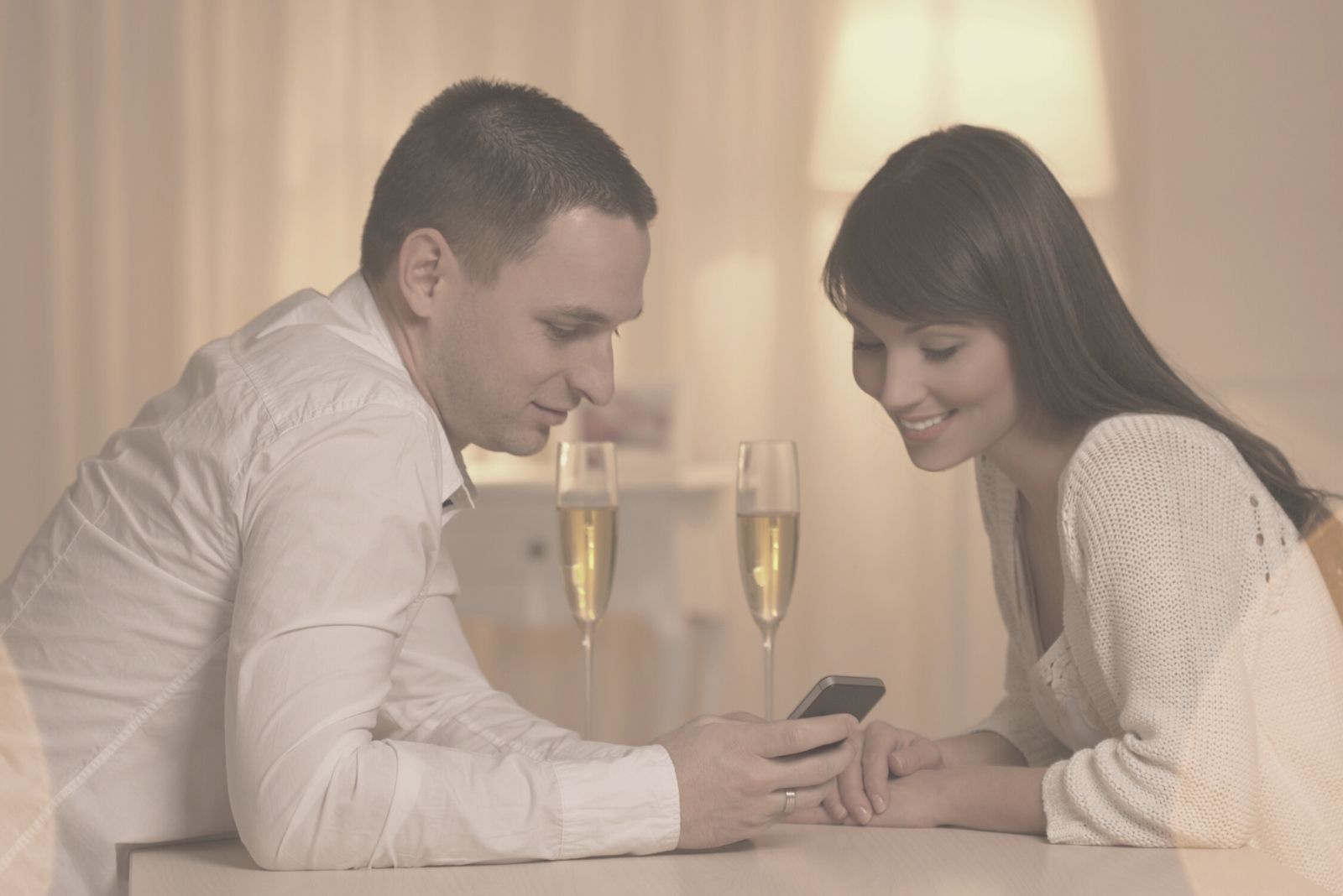 beautiful couple looking at the phone during their wine date night