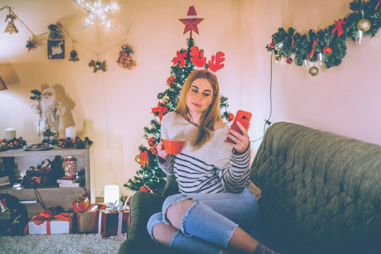 beautiful woman celebrating christmas alone drinking hot beverage and taking a selfie