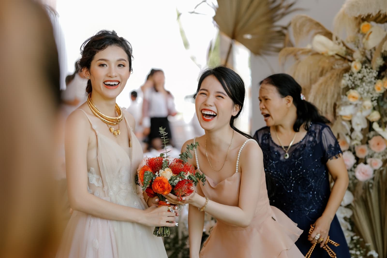 bridesmaid laughing while standing near bride