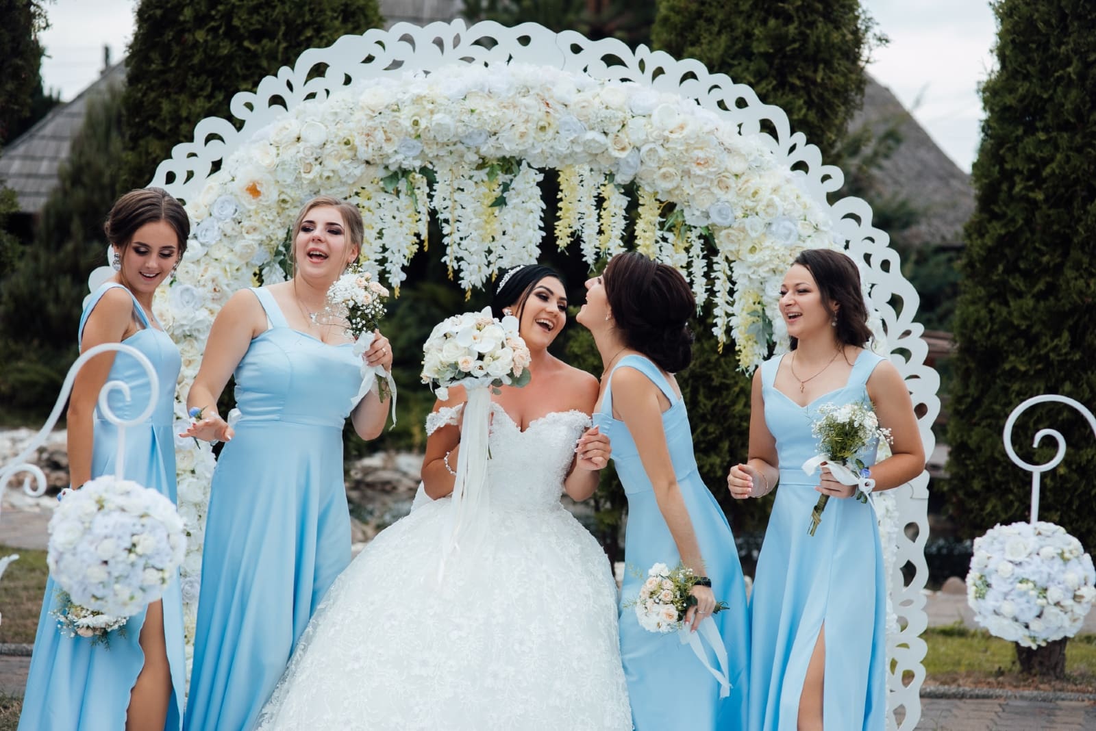 four bridesmaids in blue dresses standing near bride