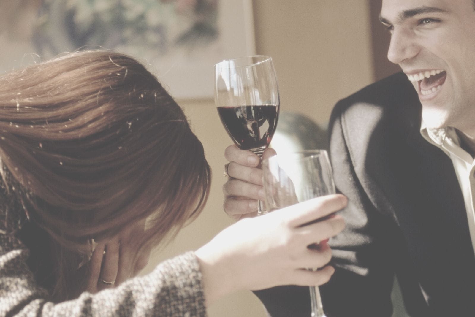 cheerful couple drinking wine laughing hard