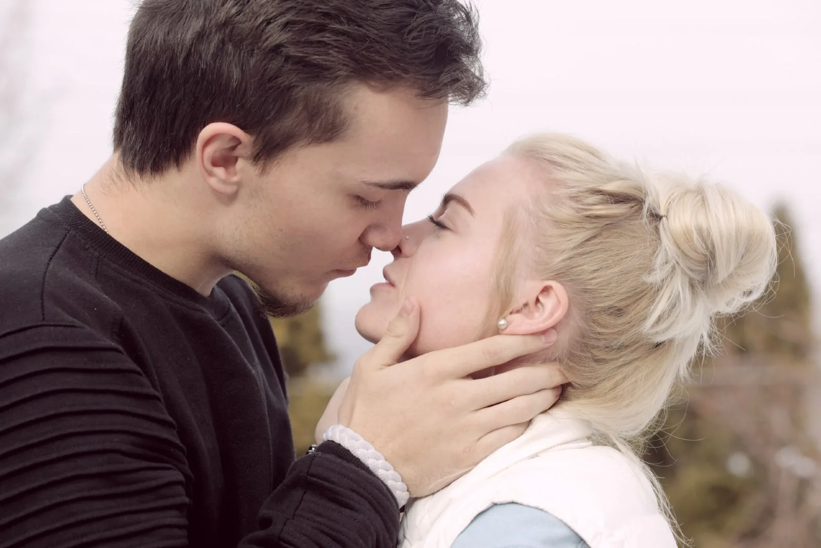 man and woman about to kiss while standing outdoor