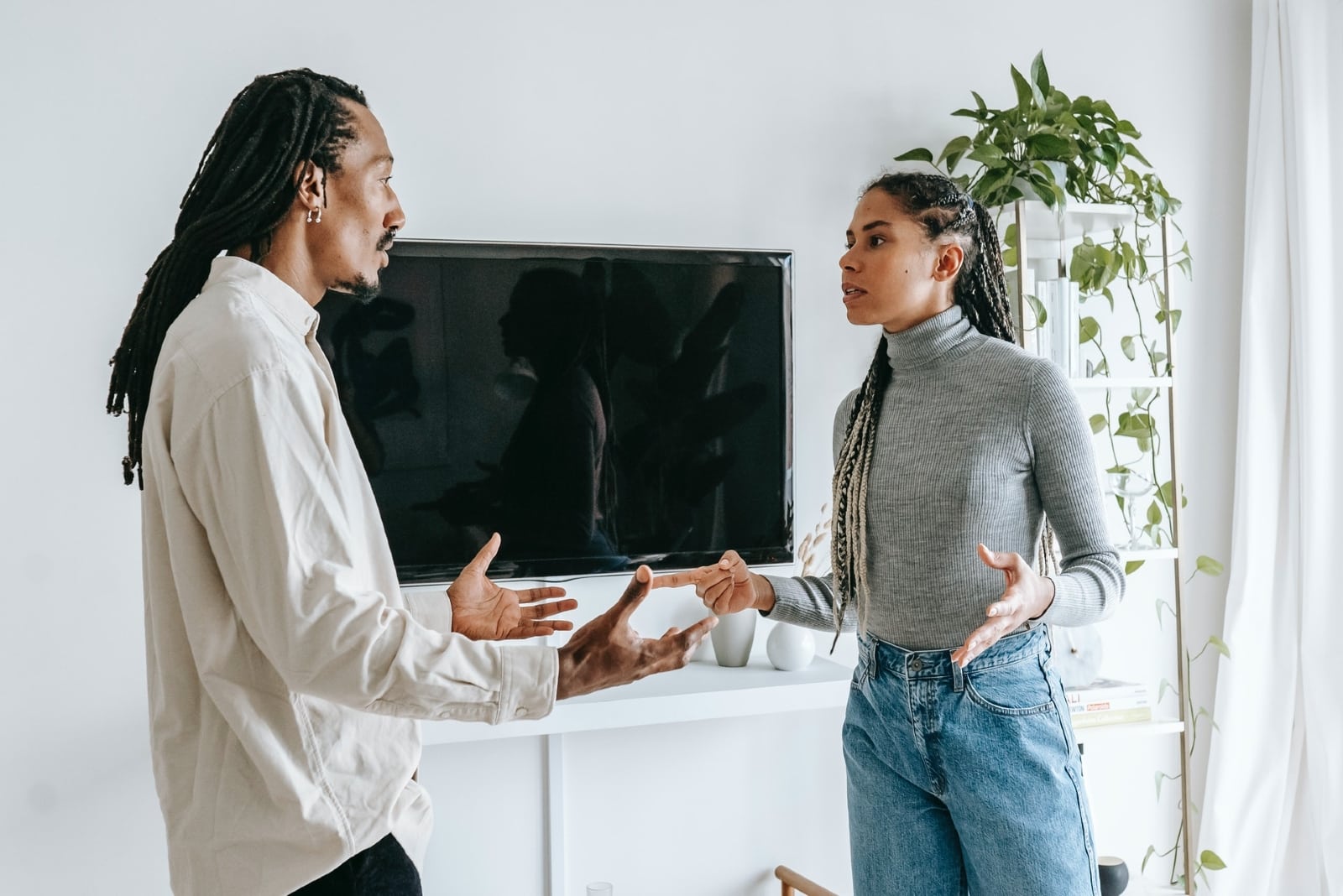 man and woman arguing while standing indoor