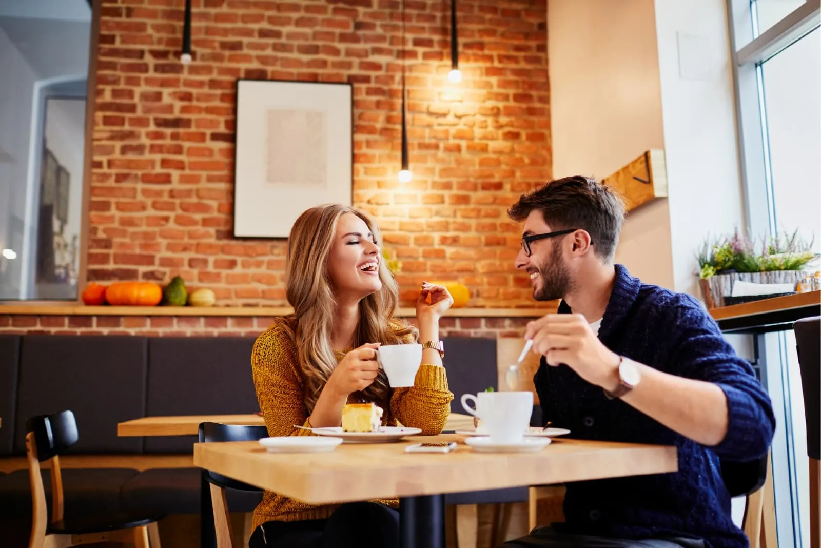 man and woman eating and having coffee