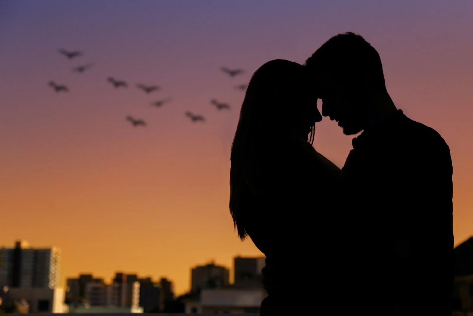 man and woman hugging during sunset