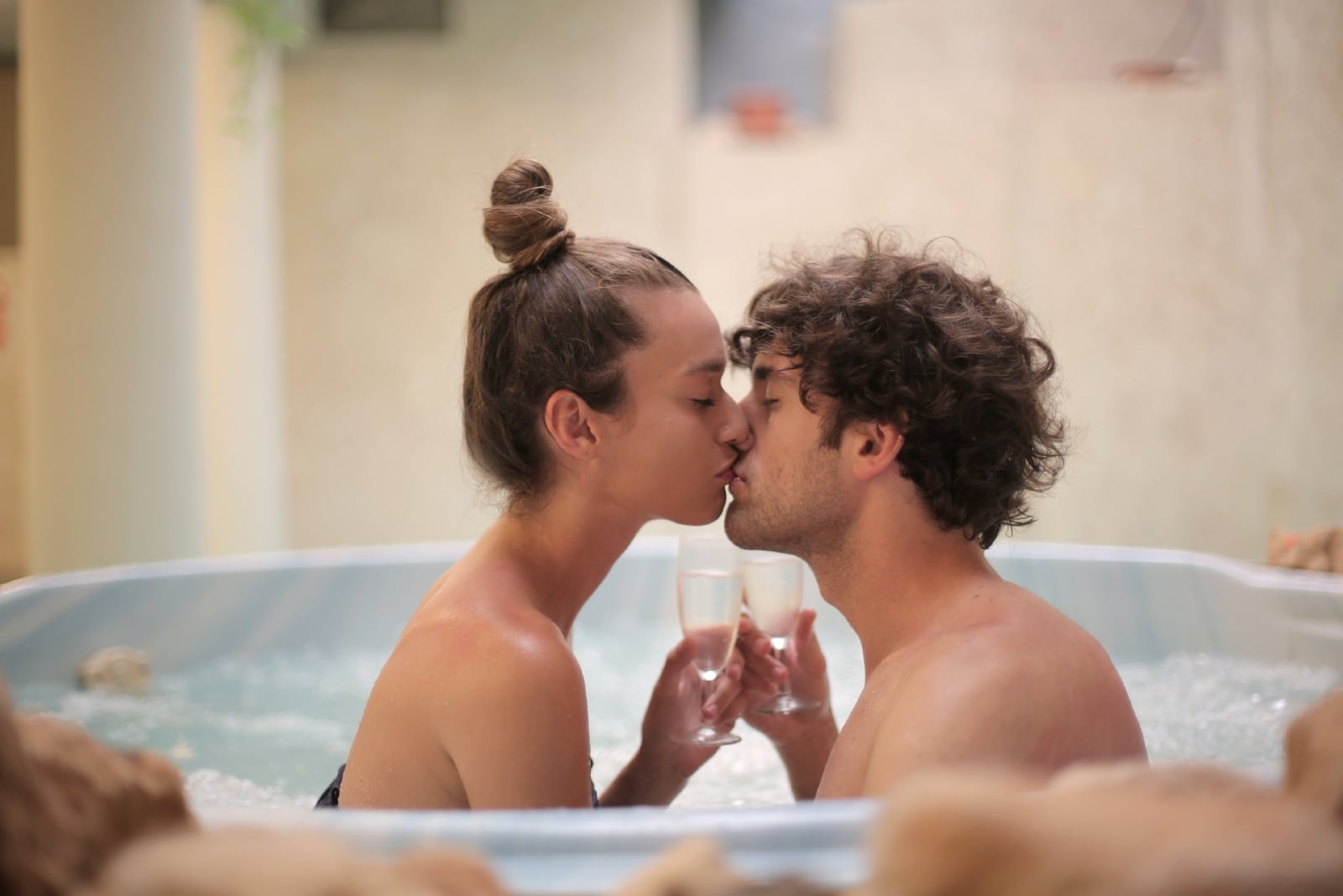 man and woman kissing in bathtub