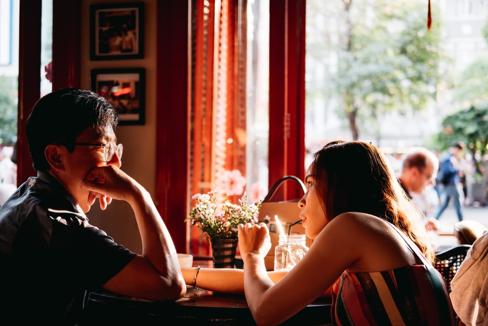 man and woman making eye contact while sitting in cafe