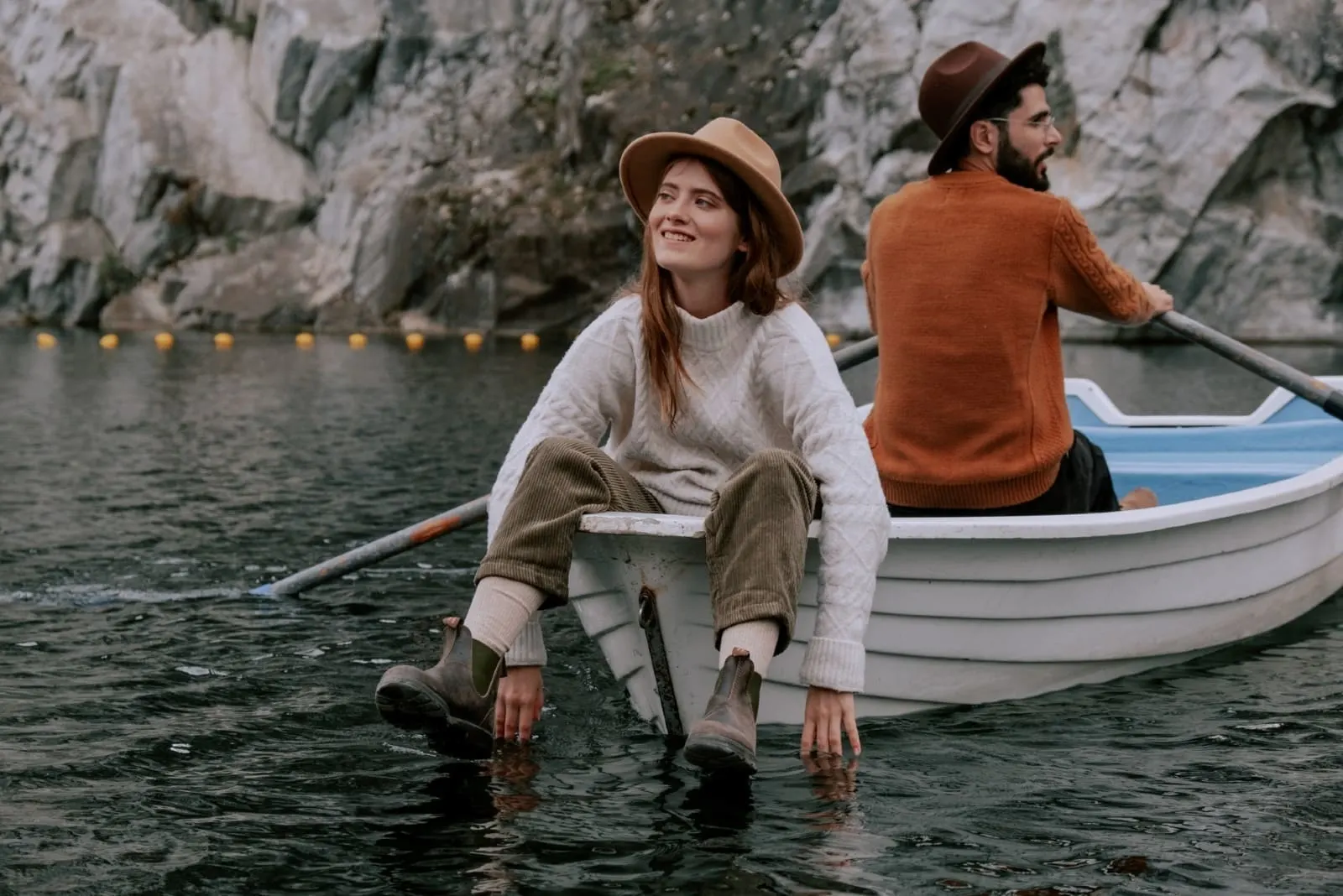 man and woman with hats sitting on boat