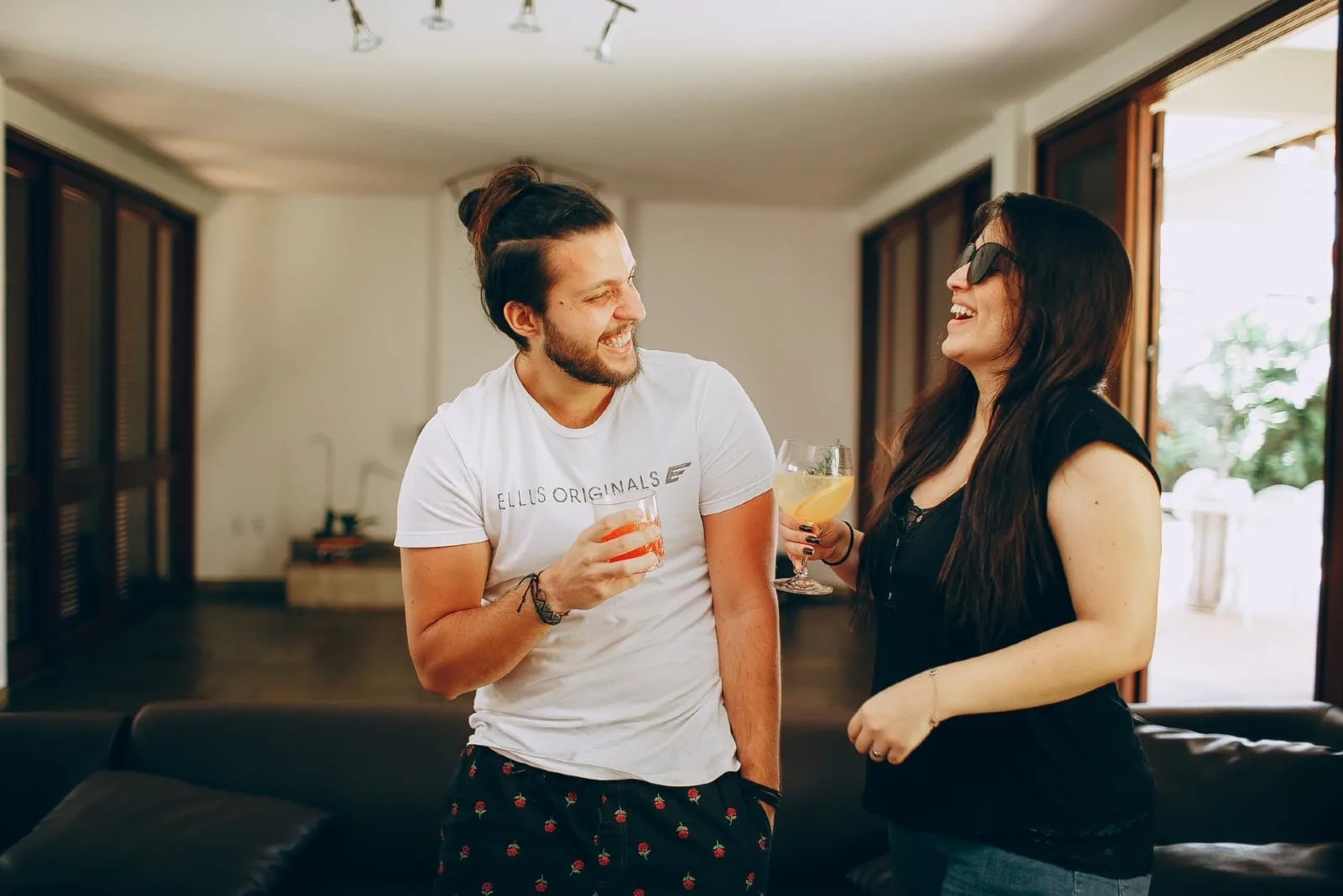 man and woman smiling while drinking cocktails