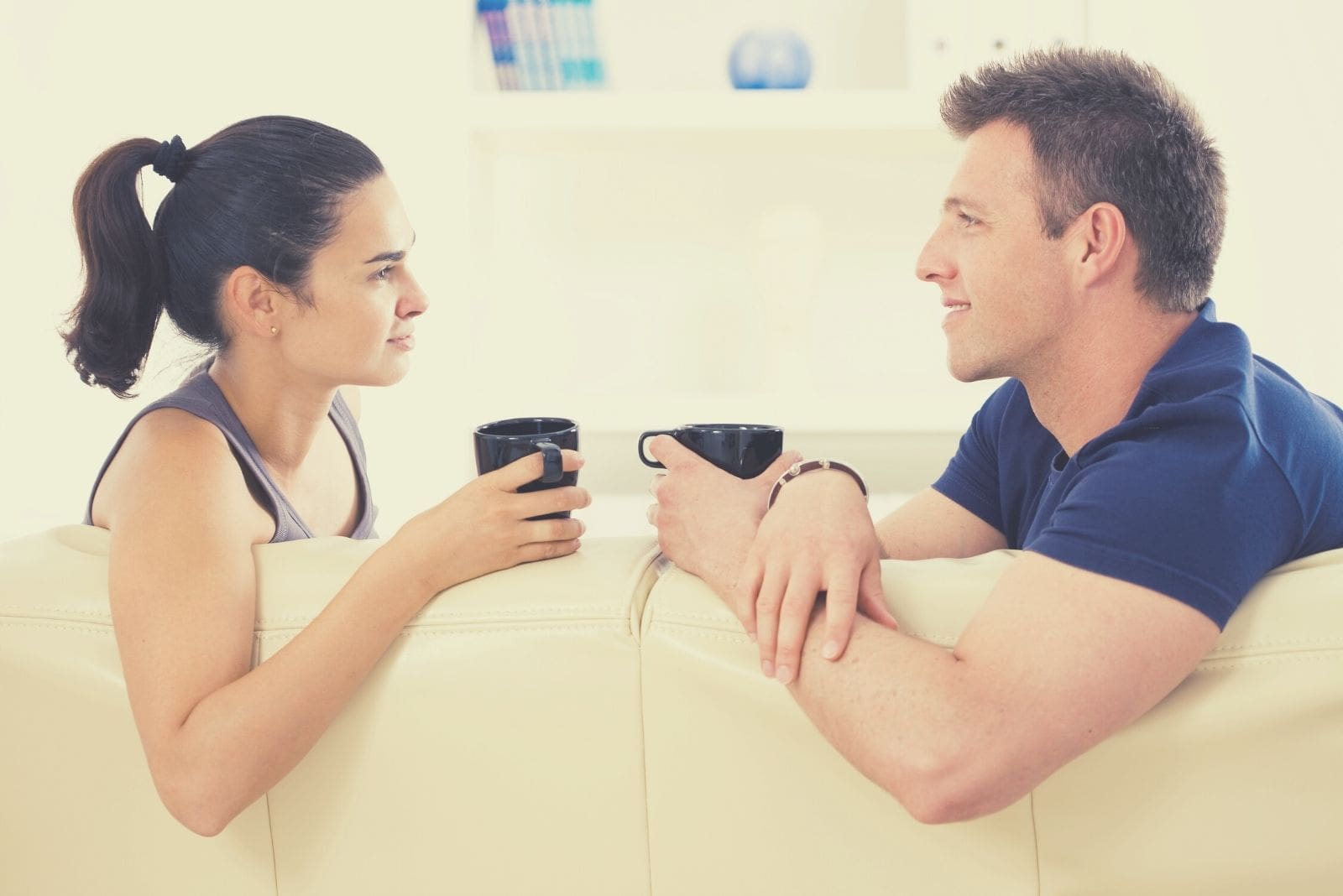 couple talking and drinking coffee in the sofa