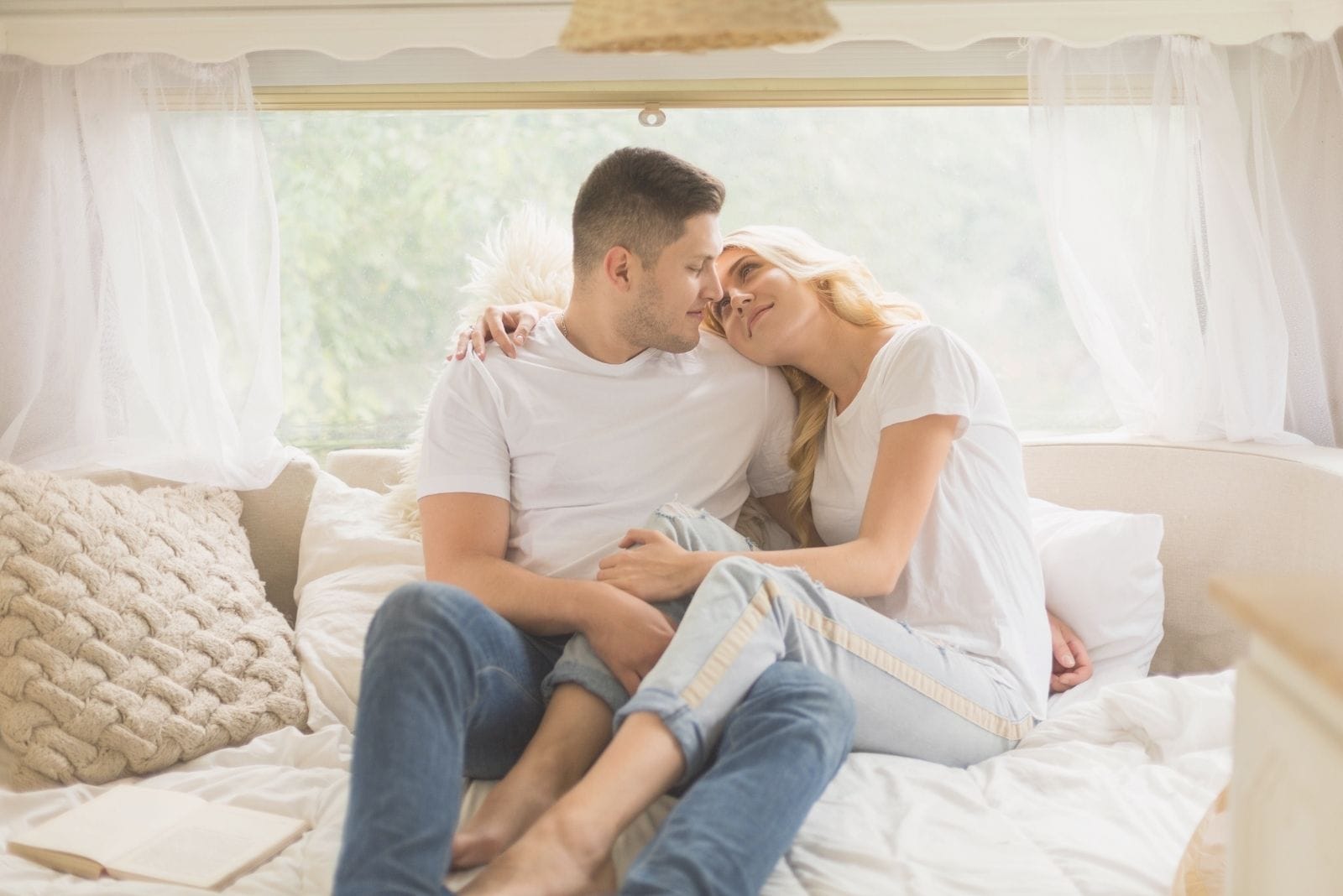 couple travelling together via a mobile home cuddling 