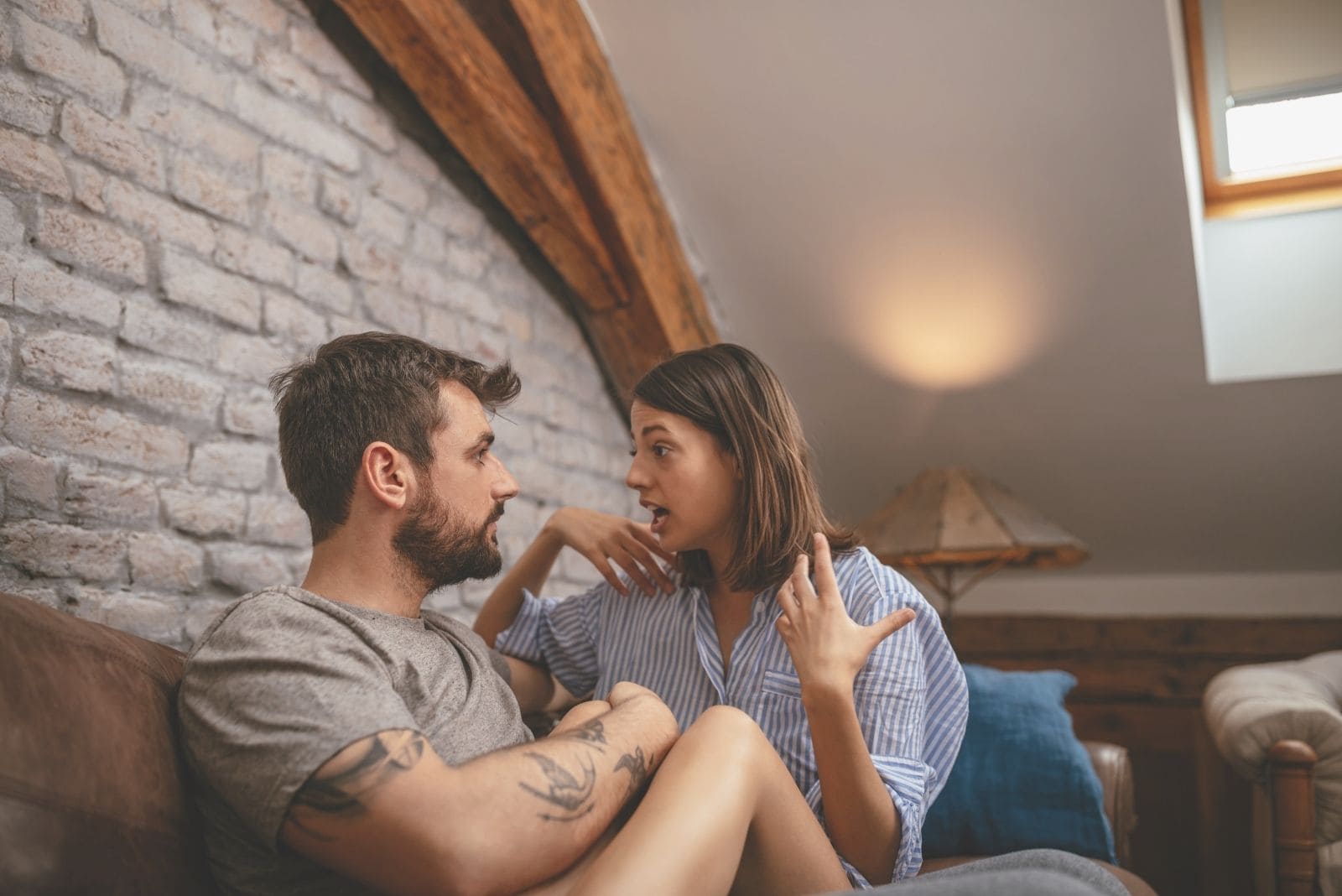 foto recortada de una pareja hablando seriamente mientras se abrazan dentro de la habitación